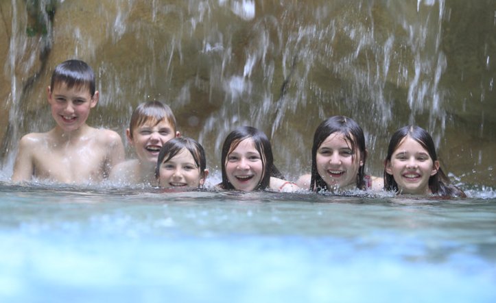 Kinder unter einem Wasserfall